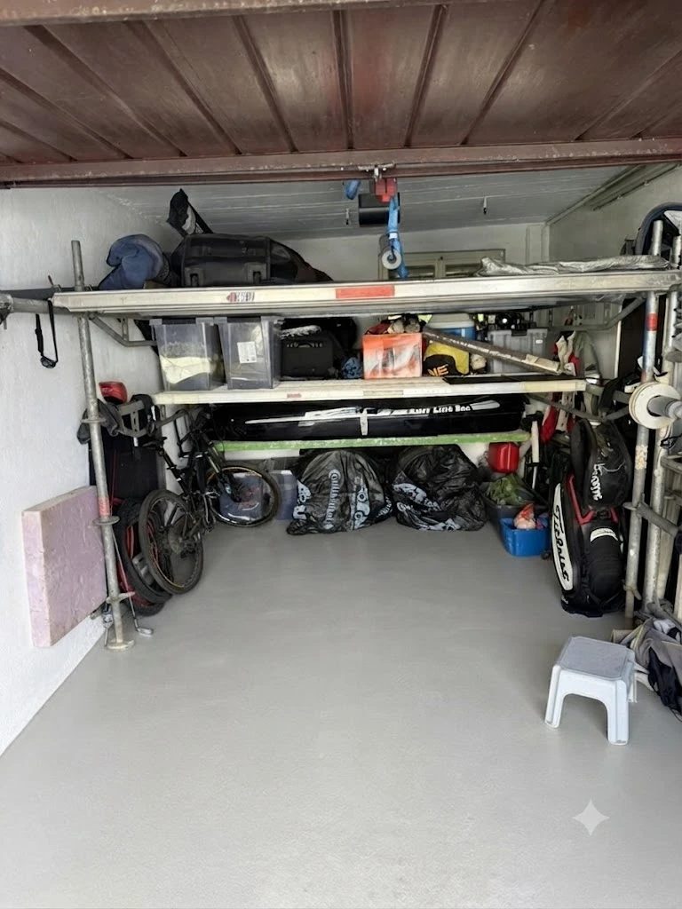 Gesamtansicht der Garage: beide Ablage-Ebenen voll beladen, der Stellplatz davor bleibt frei