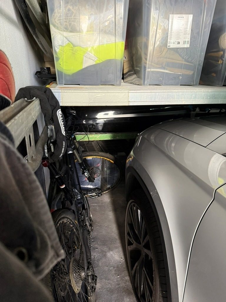 Die untere Ablage-Ebene liegt dicht über der Motorhaube des Fahrzeugs, daneben steht ein Fahrrad unter der Ebene